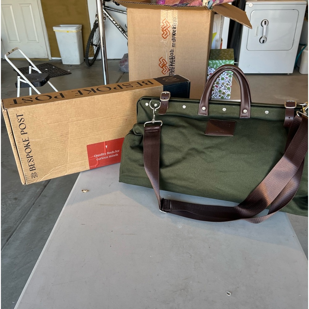 Bespokepost canvas duffel bag. Metal frame, shoulder strap, leather handles